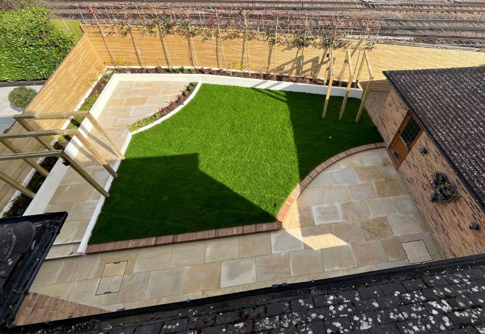 Designed courtyard garden with artificial grass, sandstone paving and planting