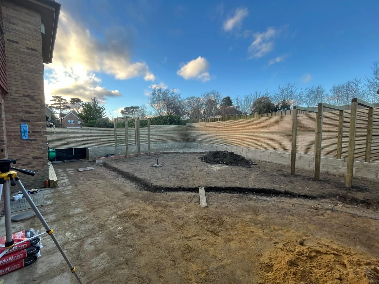 Garden mid-build with prepared ground, screens and raised beds